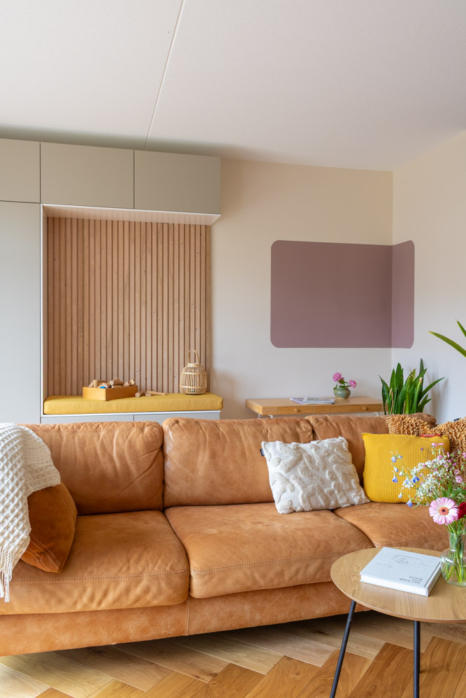 Nieuwbouw-Vroondaal-zithoek-2 Zithoek in de woonkamer bij project Vroondaal/ Den Haag met leren bank en maatwerkkast. Kleurvlak op de muur